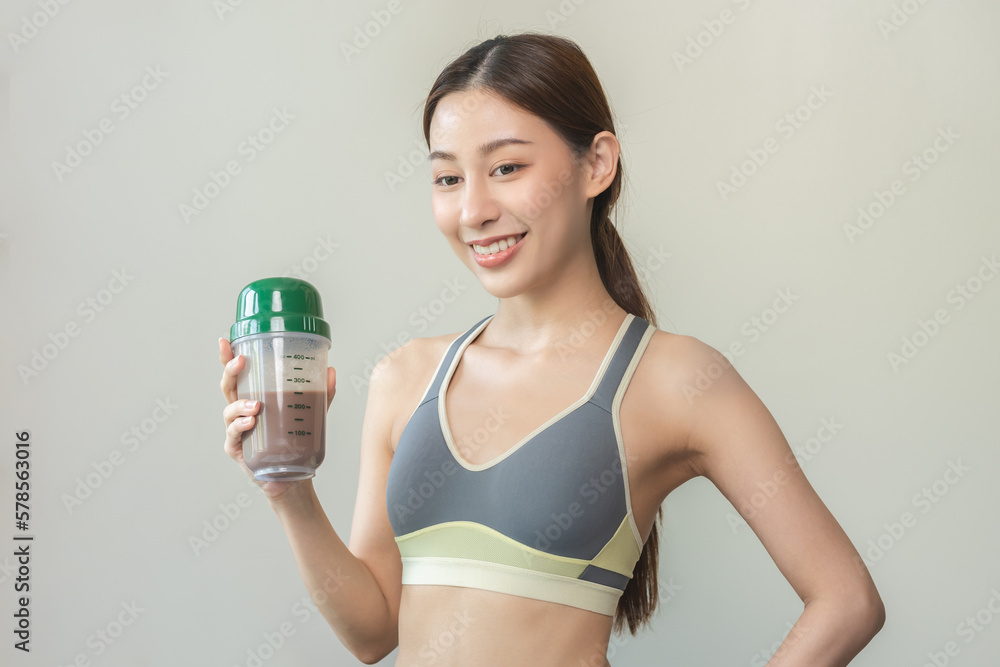 Diet meal replacement for weight loss, smile asian young woman, girl in sportswear, hand in holding protein shake bottle for drink supplement for muscle after workout at home. Healthy body care person Diet meal replacement for weight loss, smile asian young woman, girl in sportswear, hand in holding protein shake bottle for drink supplement for muscle after workout at home. Healthy body care person