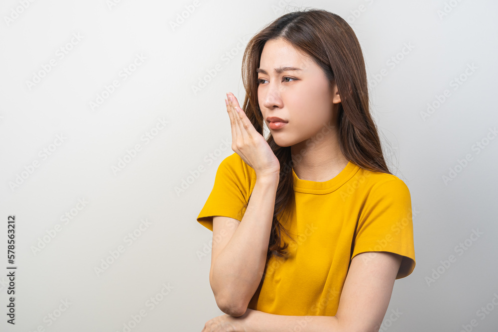 Portrait of pretty brunette hair, disgust smell bad strong asian young woman, girl checking her breath oral with hand expression face disgusting, dislike mouth odor. Isolated on white background.