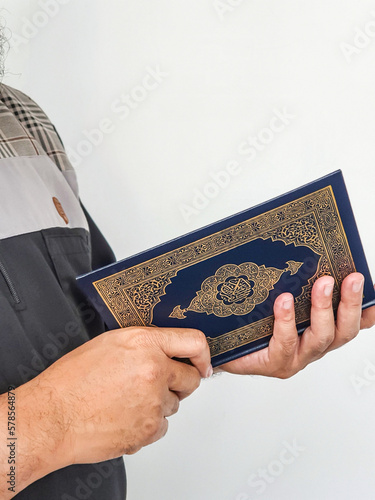 Ramadan Kareem, Eid Mubarak or Islamic concept. The Islamic holy book, Quran or Kuran, on grey background. Arabic words on the book means 