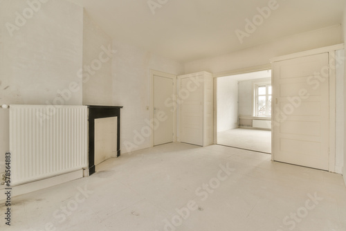 an empty room with a radiaing heater on the wall and door to the other room in the background photo