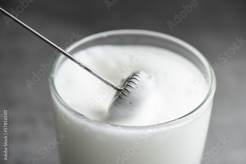 Froth milk with milk frother photo