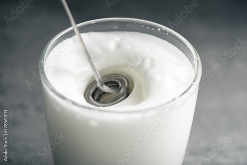 Froth milk with milk frother photo