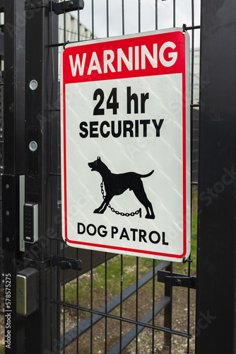 Warning Guard Dog On Duty Sign on a gate. 24 hours security dog patrol warning sign. Security patrol sign with guard dog photo