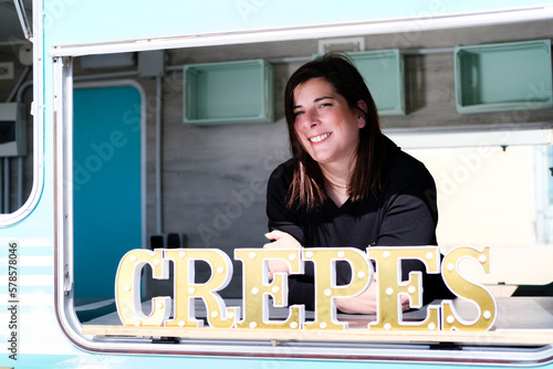 smiling entrepreneur proudly shows off her crepe hawking business.