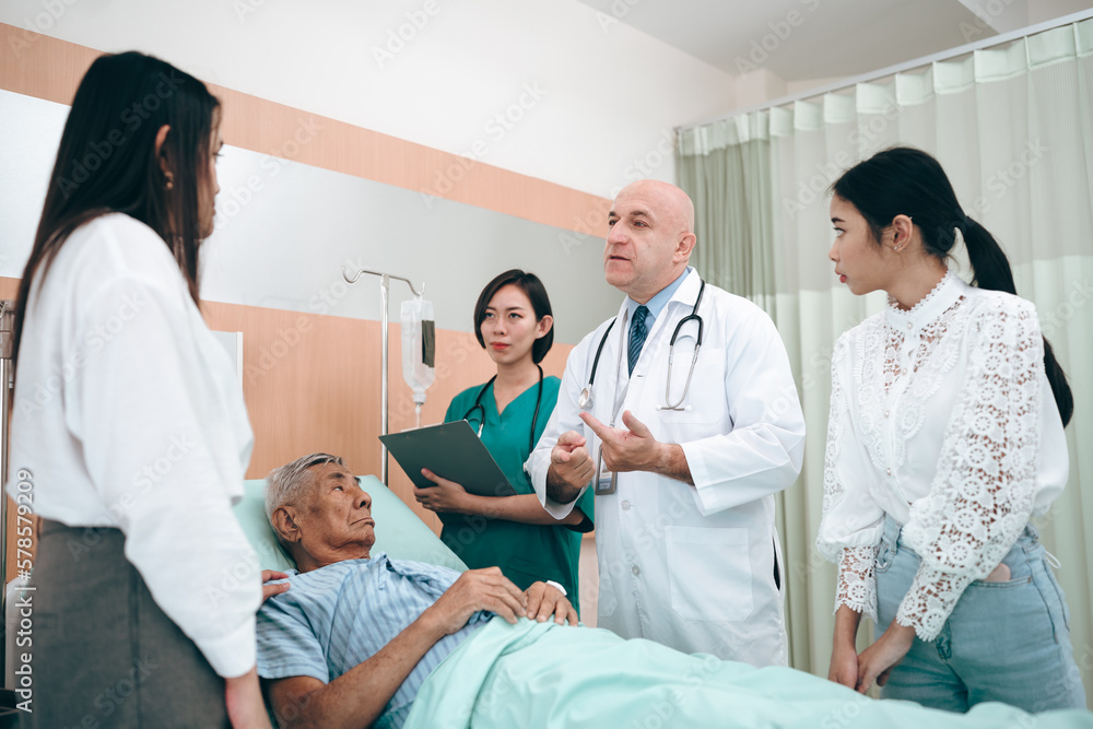 professional doctor standing by explain the treatment information via male elderly patient lying in bed in private hospital sickroom. The treatment program is suitable for people to socialize elderly professional doctor standing by explain the treatment information via male elderly patient lying in bed in private hospital sickroom. The treatment program is suitable for people to socialize elderly