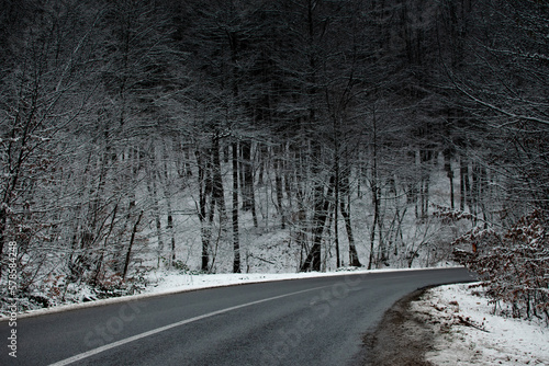 Mountain winter road landscape in Apuseni mountains, Romania. Dark misterious fog