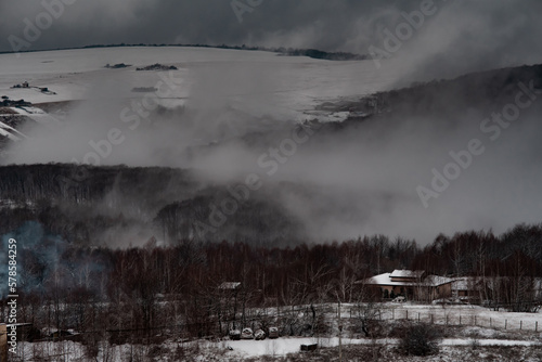 Mountain winter road landscape in Apuseni mountains, Romania. Dark misterious fog © landscapeaway