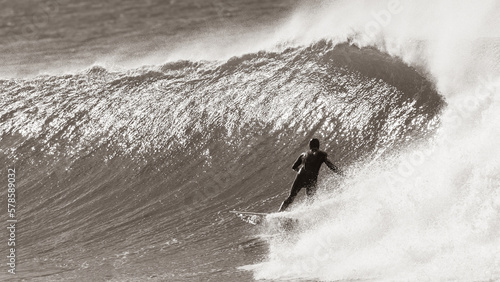 Surfer Surfing Unrecognizable Riding Cold Ocean Wave In Vintage Sepia Retro Tone Photograph.