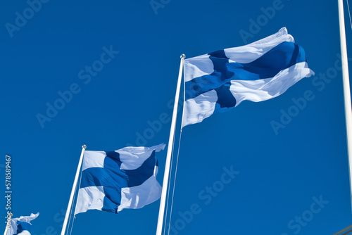 finnish national flags on the wind against the blue sky