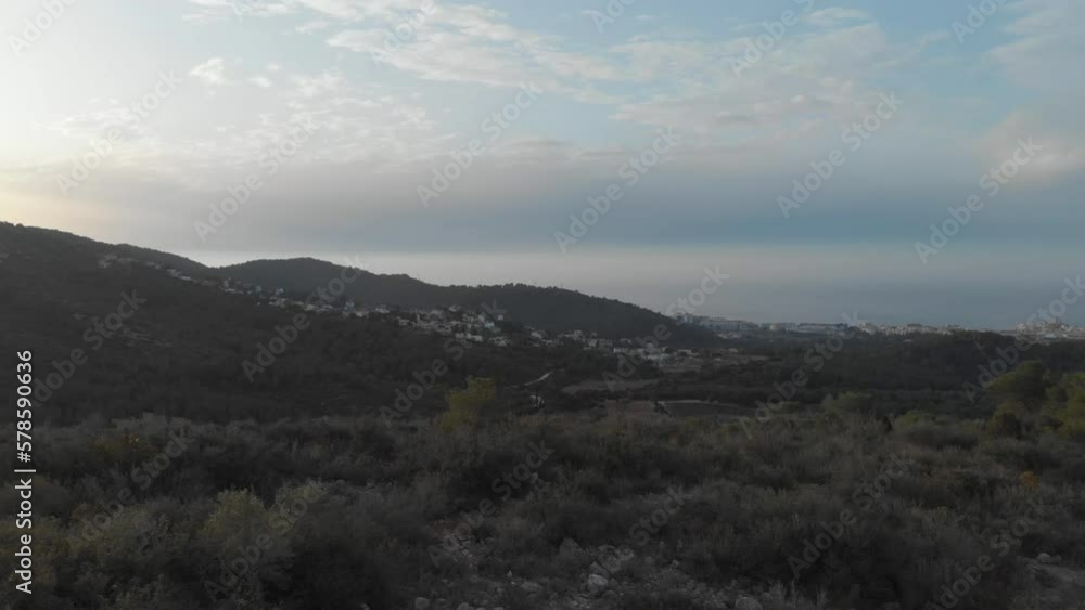 Sideways drone track reveals hill scape during sunset, valley and bright sky contrast Sideways drone track reveals hill scape during sunset, valley and bright sky contrast