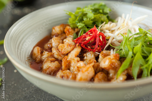 chicken pieces in batter in hot sauce with chili and soy sprouts, Asian cuisine