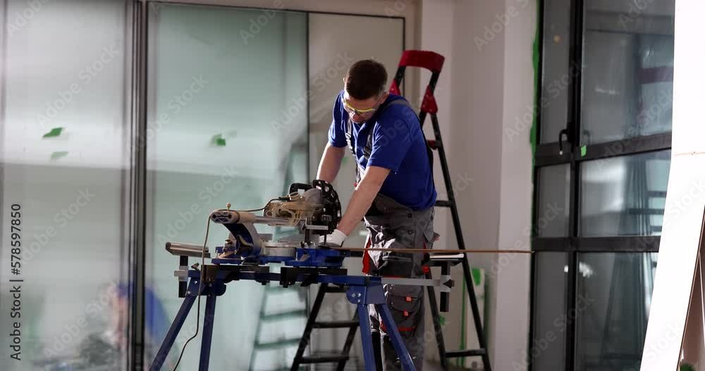 Professional worker with electric circular disk saw cuts laminate Professional worker with electric circular disk saw cuts laminate