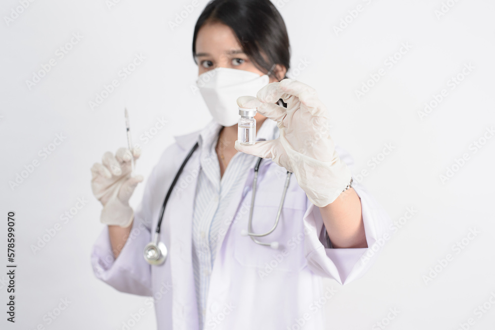Study of COVID-19 infection. Female doctor examines medicine for illness, man mask with syringe and jar in front with copy space coronavirus virus