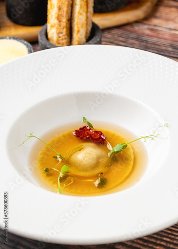 Ravioli consomme on a white porcelain plate. Healthy eating concept