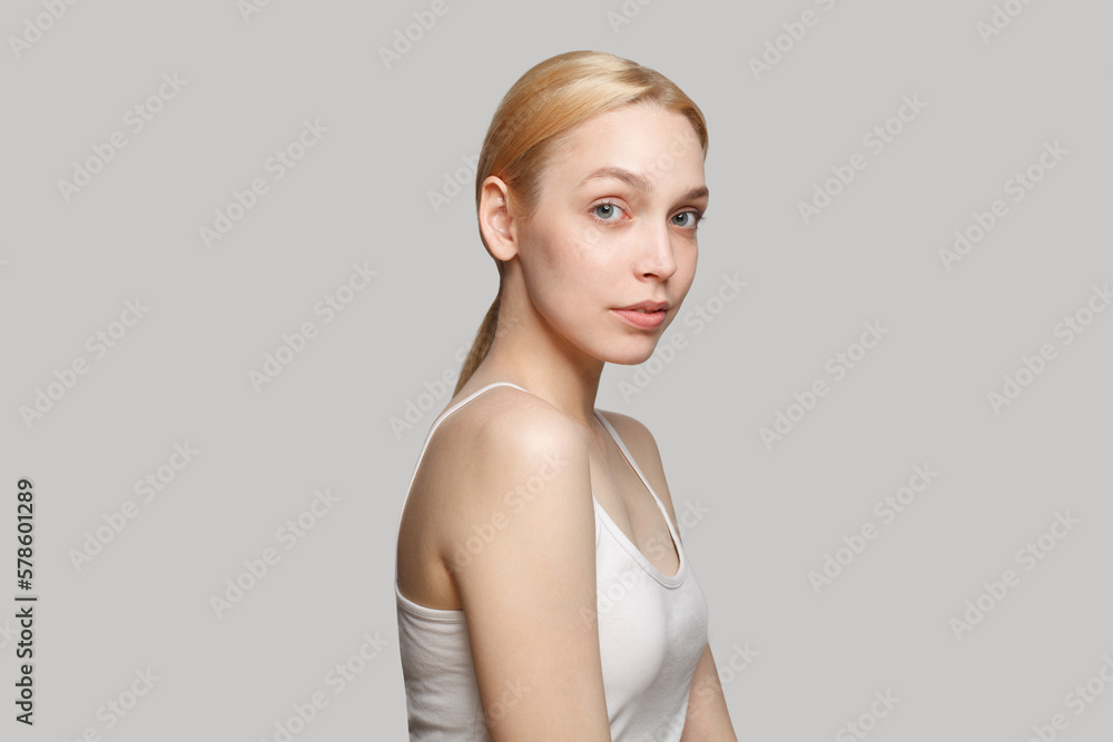 Fresh blonde woman in white top isolated on grey background. Beauty, cosmetics, skincare, glamour Fresh blonde woman in white top isolated on grey background. Beauty, cosmetics, skincare, glamour