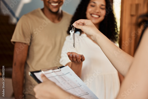 Realtor keys, couple home purchase and real estate contract of a happy woman and man. House, happiness and property sale of residential homeowner people ready for moving with mortgage paperwork