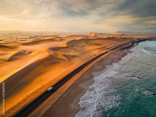Aerial top view of street road with Namib Desert Safari, sand dune, coast sea in Namibia, South Africa. Natural landscape background at sunset. Famous tourist attraction. Sand in Grand Canyon