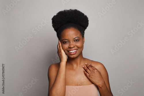Young healthy female model face. Pretty woman brunette with clean fresh dark skin on grey background. Skincare and facial treatment concept