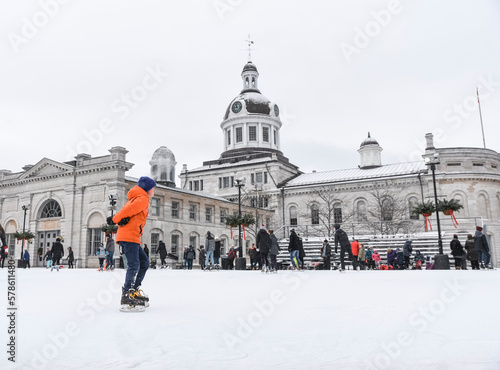 Adolescent boy skating on outdoor ice rink on cloudy day. photo