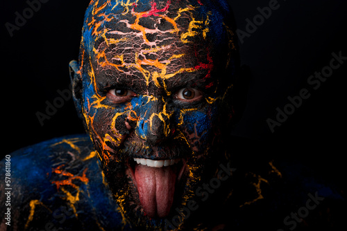 Conceptual Portrait of a brutal man painted in face art style over bla photo