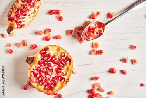 Juicy pomegranate fruit on white wood background. Pomegranate pieces.