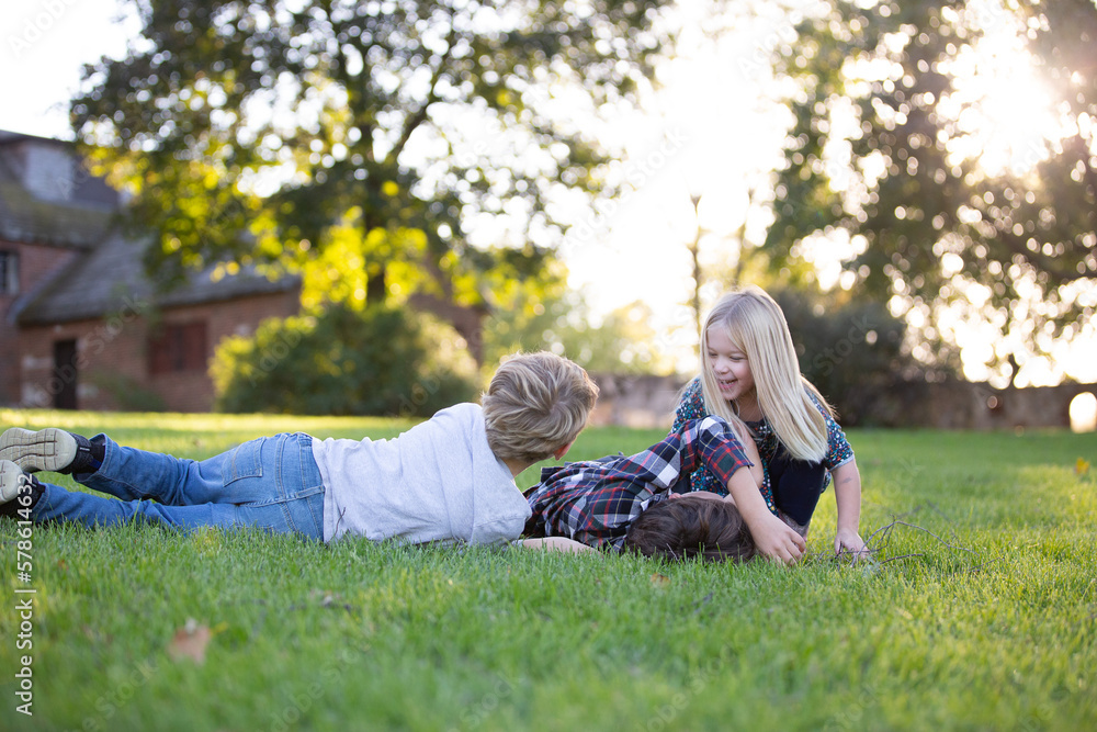 kids siblings playing together in grassy field outside kids siblings playing together in grassy field outside