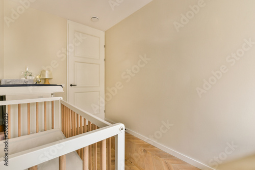 a baby's room with a cribt in the corner and an open door on the right side photo