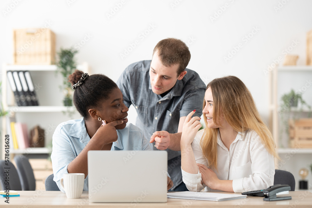 Multiethnic freelance coworkers working together on laptop Multiethnic freelance coworkers working together on laptop
