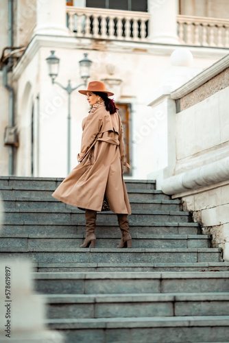 Wallpaper Mural Outdoor fashion portrait of young elegant fashionable brunette woman, model in stylish hat, choker and light raincoat posing at sunset in European city. Torontodigital.ca