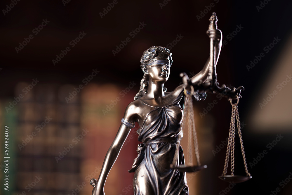 Judge chamber. Judge’s gavel, Themis sculpture, scale and legal books in the bookshelf. Judge chamber. Judge’s gavel, Themis sculpture, scale and legal books in the bookshelf.