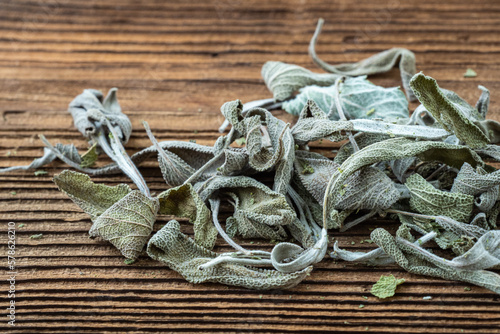 Dried sage leaves on dark rustic wooden background.