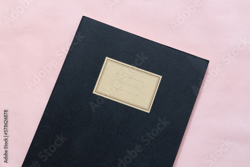 notebook nero chiuso su sfondo rosa chiaro foto orizzontale photo