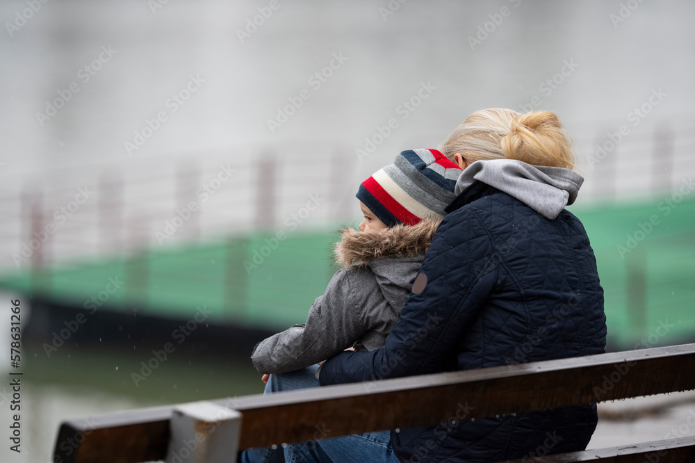 A mother with a child is sitting on a bench A mother with a child is sitting on a bench