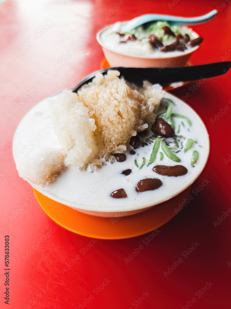 Malaysia traditional iced sweet dessert Cendol served in a bowl with coconut milk and red beans. Malaysia traditional iced sweet dessert Cendol served in a bowl with coconut milk and red beans.