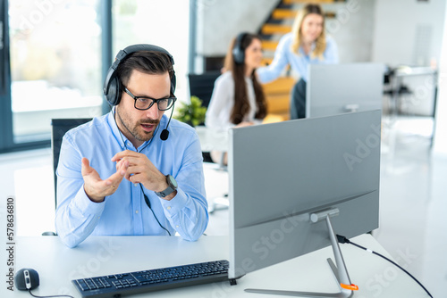 Dedicated male customer service representative communicating with customer trying to provide appropriate solutions for client issues at call center.