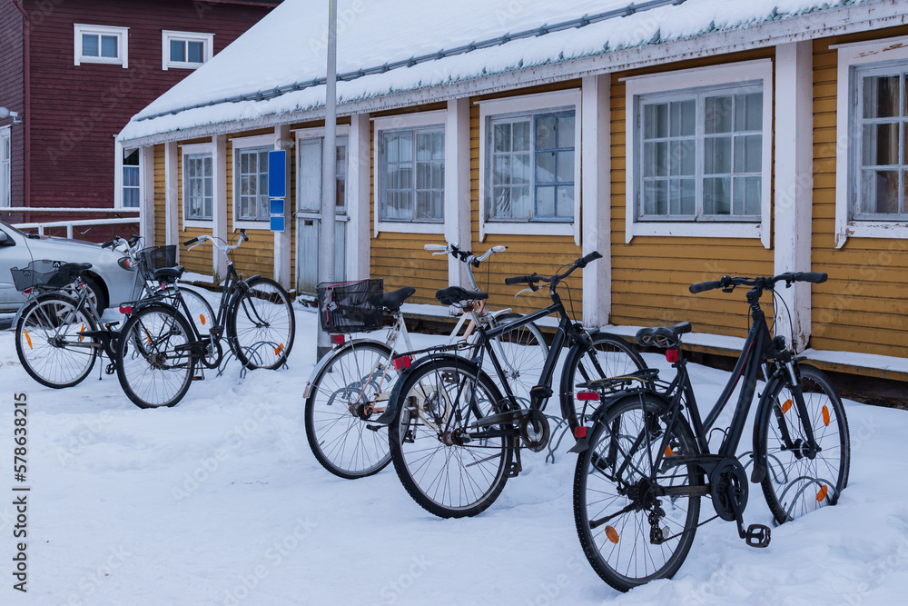 bicycle parking on the background of a yellow house, use of bicycles in winter