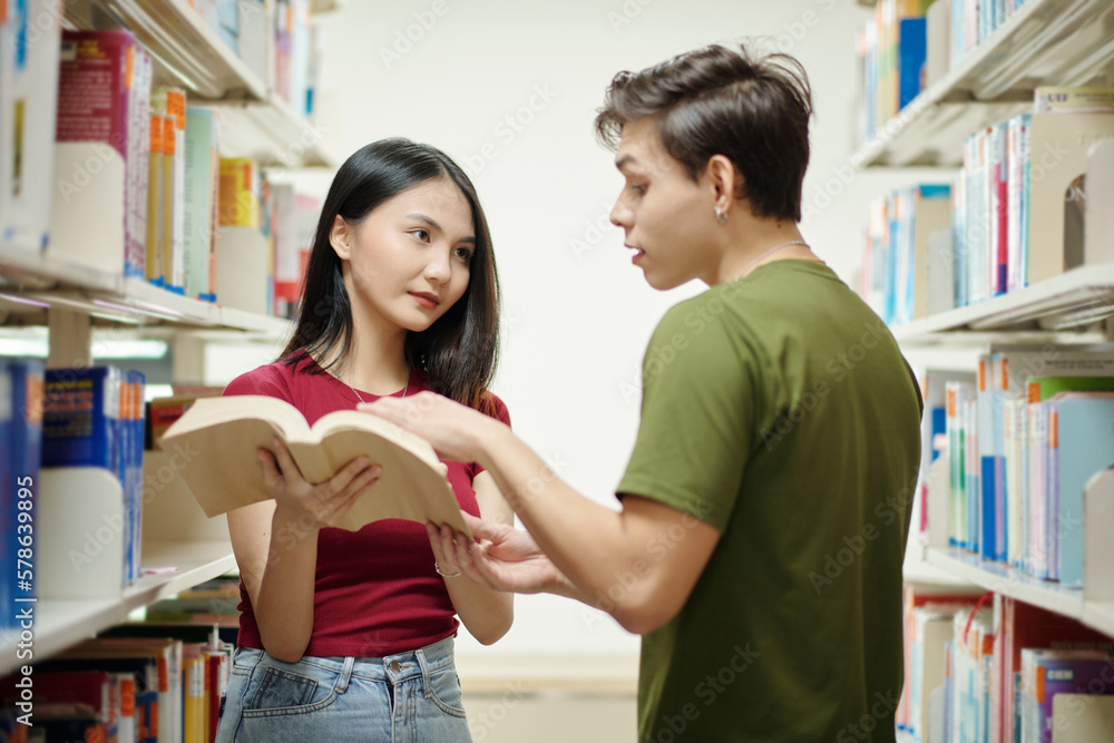 College students searching for books for reseach in library College students searching for books for reseach in library