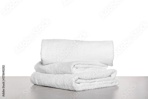 Soft terry towels on light table against white background
