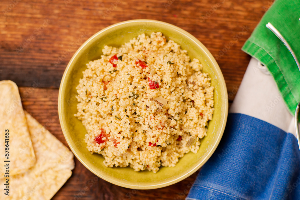 Rice bread and couscous tomato and spice salad. Tabbouleh salad. Wooden background. Food simple concept. Rice bread and couscous tomato and spice salad. Tabbouleh salad. Wooden background. Food simple concept.