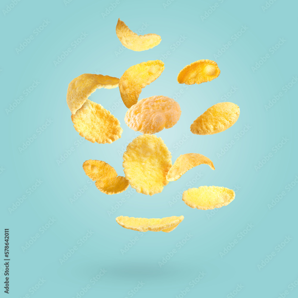 Many tasty corn flakes falling on light blue background Many tasty corn flakes falling on light blue background