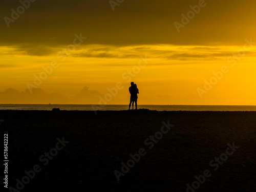 Sunrise silhouettes - golden hour romance at the seaside