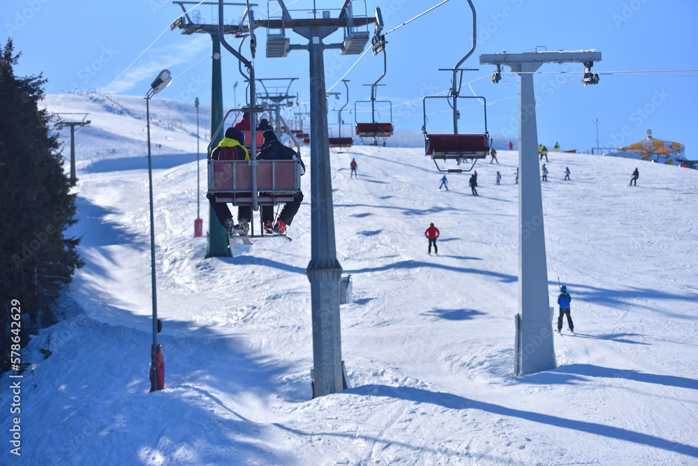 Slope-Side View - Elevated Shot of Skiers and Chairlifts in the Heart of the Winter Sports Action Slope-Side View - Elevated Shot of Skiers and Chairlifts in the Heart of the Winter Sports Action