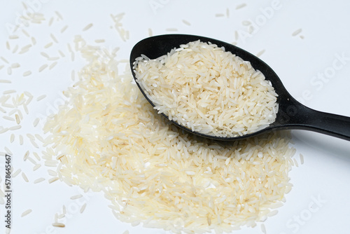 Biały ryż jaśminowy na czarnej łyżce 