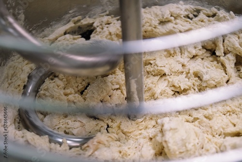 industrial dough mixer kneads the dough. Raw dough in a industrial bakery dough mixer, food concept. close-up	