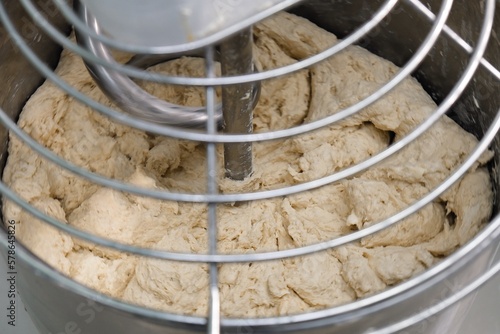 industrial dough mixer kneads the dough. Raw dough in a industrial bakery dough mixer, food concept. close-up	