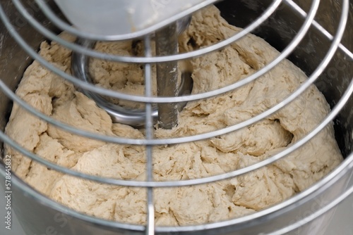 industrial dough mixer kneads the dough. Raw dough in a industrial bakery dough mixer, food concept. close-up 