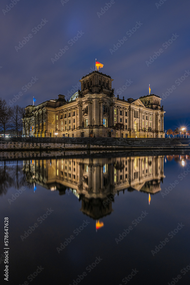 Reichstag at night. Illuminated government building in Berlin. Government district in the center of the capital of Germany. River Spree with reflection on the water surface