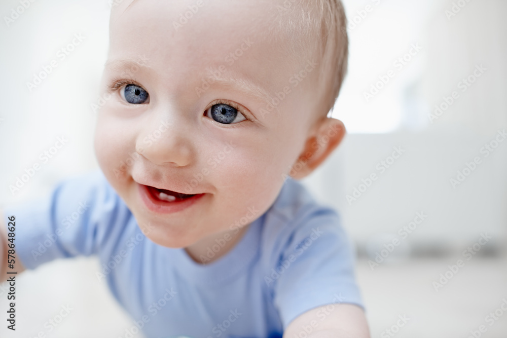 Crawling is a lot of fun. A cute little baby boy smiling with two teeth.