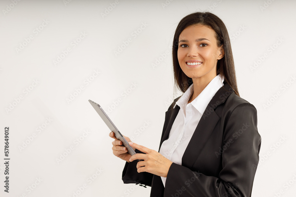 Portrait of successful business woman with tablet in her hands, dressed in white shirt and black jacket on isolated white background. Studio shot of attractive brunette girl looking into the camera. Portrait of successful business woman with tablet in her hands, dressed in white shirt and black jacket on isolated white background. Studio shot of attractive brunette girl looking into the camera.