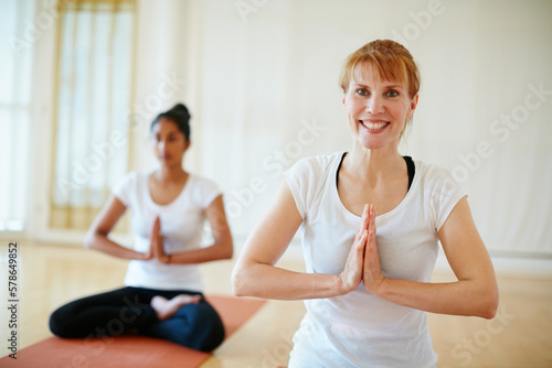 Achieving health and happiness through yoga. two women doing yoga together in a studio.
